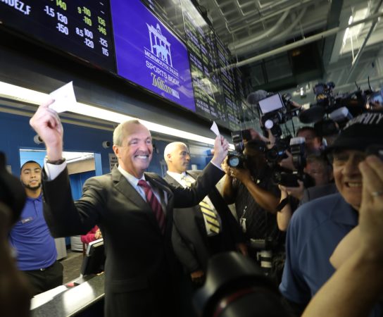 Governor Phil Murphy holding betting ticket in New Jersey sportsbook