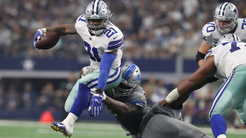 Dallas Cowboys running back Ezekiel Elliott (21) leaps while running the ball away from Detroit Lions defensive tackle A'Shawn Robinson (91) in the third quarter at AT&T Stadium.