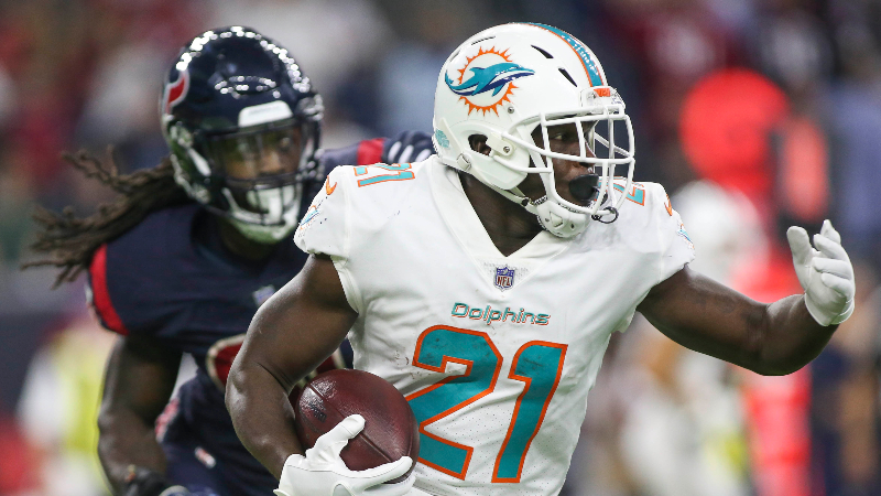 Miami Dolphins running back Frank Gore (21) runs with the ball as Houston Texans linebacker Jadeveon Clowney (90) defends during the third quarter at NRG Stadium.