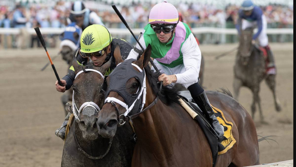 An action-packed shot of a horse race at Monmouth Park Racetrack in New Jersey, with thoroughbreds and jockeys racing down the track. Spectators eagerly watch the thrilling event from the stands. The image relates to recent legislative proposals, Senate Concurrent Resolutions 31 and 66, aimed at amending the state constitution to permit slot machine gambling at New Jersey racetracks like Monmouth Park and the Meadowlands."