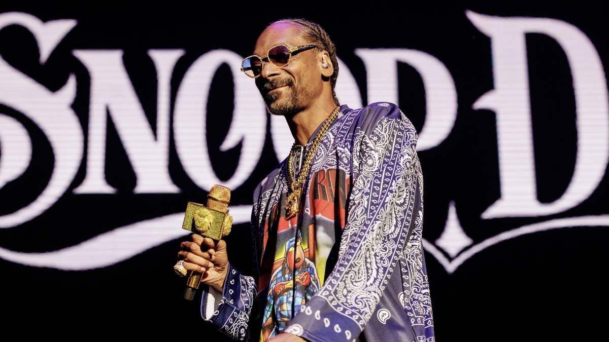 Image shows Snoop Dogg standing confidently against a vibrant background that reflects his energetic style. As the mastermind behind Dogg House Casino's unique audio environment, Snoop has crafted an industry-first experience with original music and beats. This exclusive soundscape sets the casino apart from traditional online platforms, offering an innovative auditory experience not found in other sweepstakes casinos.