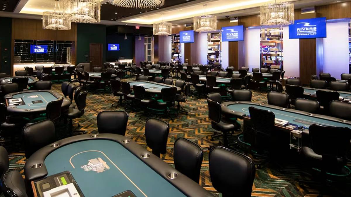 Photo of the bustling casino floor at Rivers Casino in Schenectady, New York. Patrons are engaged with various slot machines and table games under colorful, ambient lighting. The lively atmosphere reflects the casino's vibrant energy and diverse entertainment options.