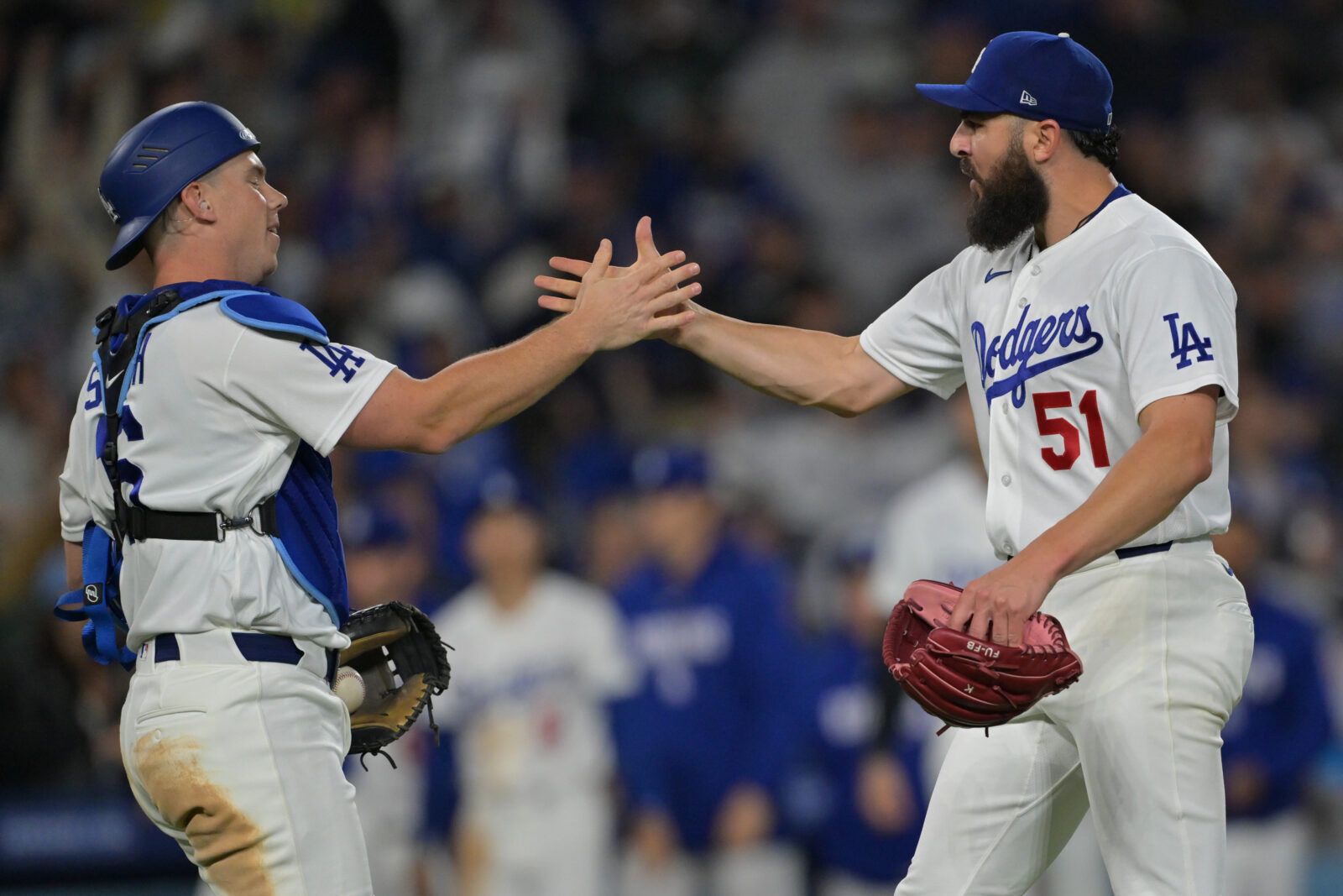 Dodgers catcher Will Smith (16) shakes hands with pitcher Alex Vesia (51) after the final out of the ninth against the New York Mets at Dodger Stadium.