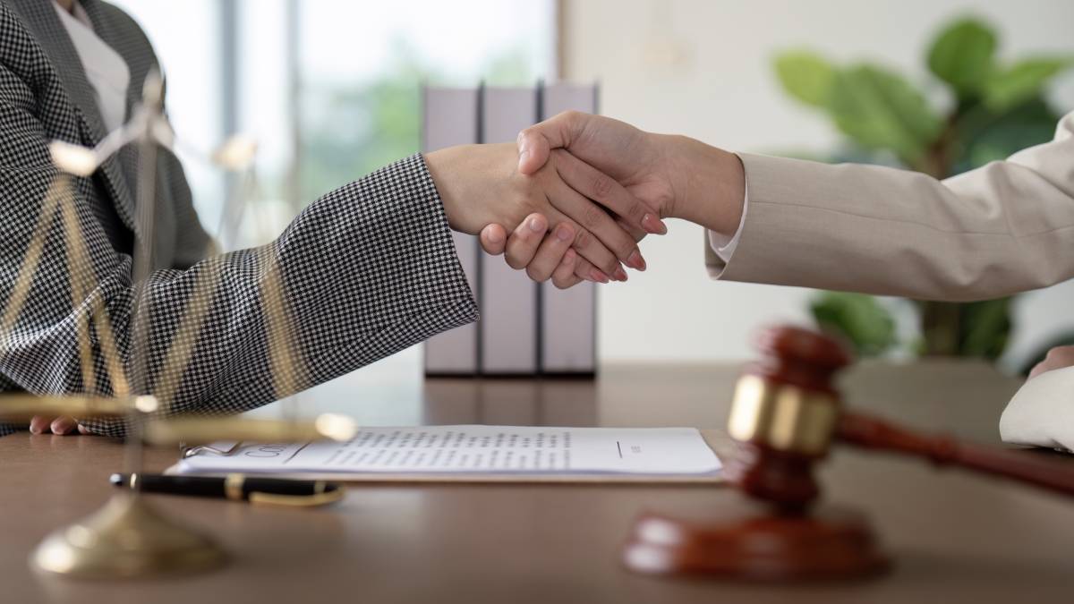 A handshake in a law office, representing fairness in legal cases and illustrating what a settlement means.