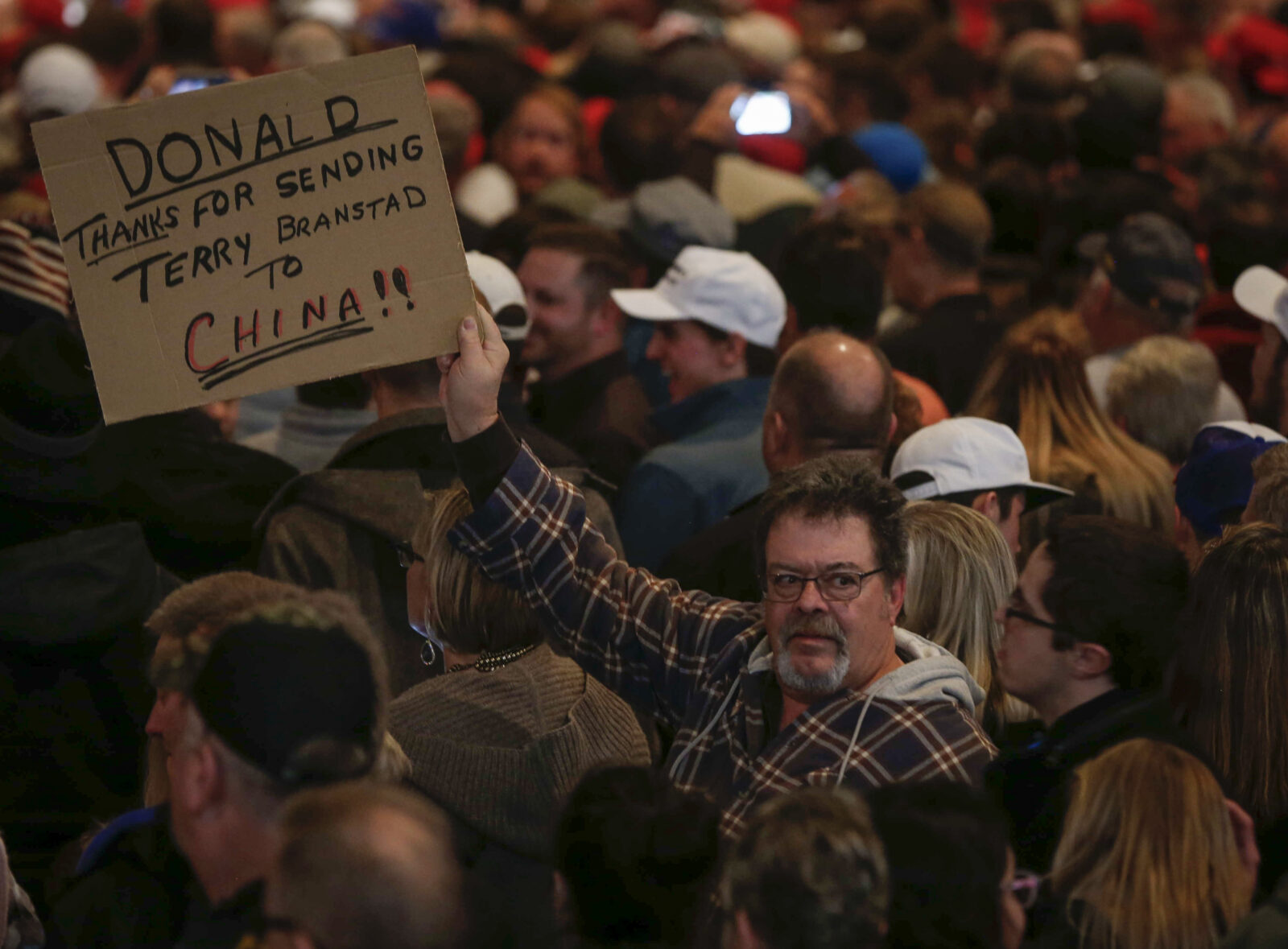 A man holds a sign reading "Thanks for Sending Terry Branstad to China" during president-elect Donald Trump's Thank You Tour visit to Des Moines.