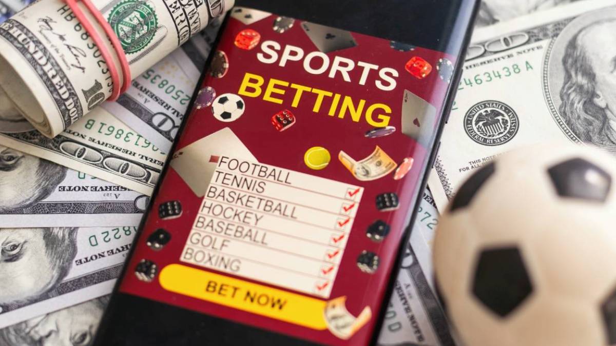 Close-up of sports betting slips placed next to cash and a smartphone