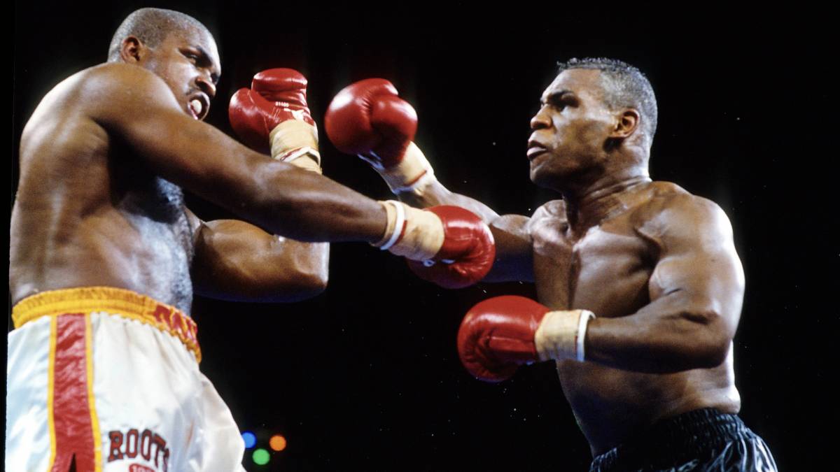 Mike Tyson in the boxing ring throwing a powerful punch during a championship fight