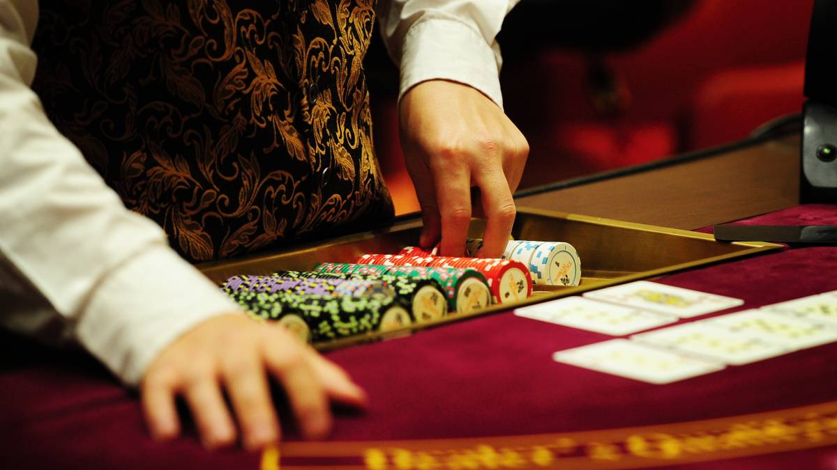 a blackjack dealer prepares the cards for a new game.