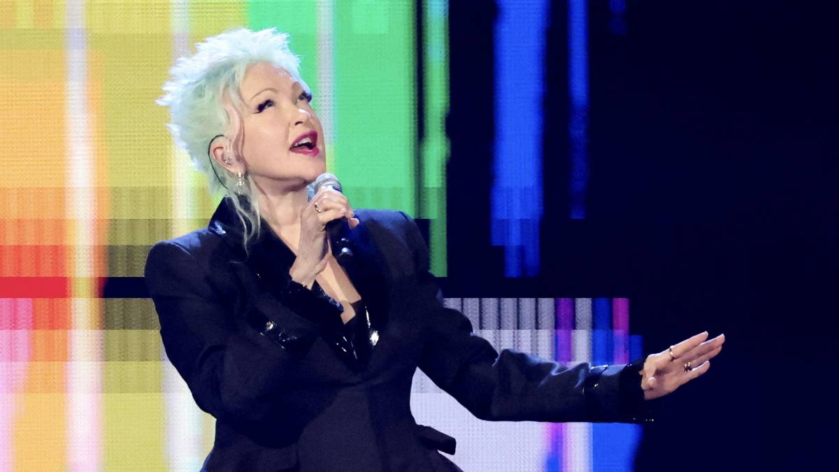 Cyndi Lauper singing into a microphone during a live performance.