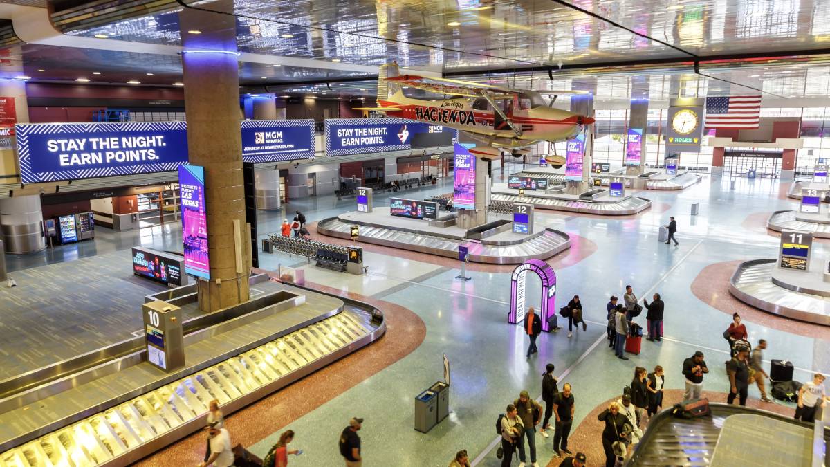 Travelers waiting for checked bags at a baggage claim carousel in Harry Reid International Airport in Las Vegas.
