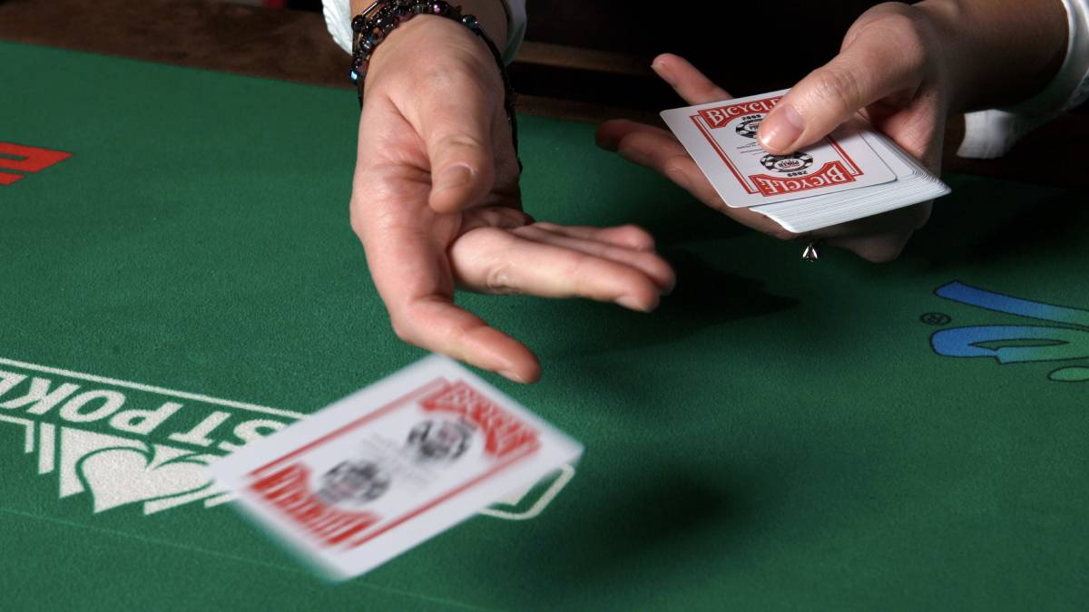 Dealer distributing face-down cards to players at a Venetian Las Vegas poker table.